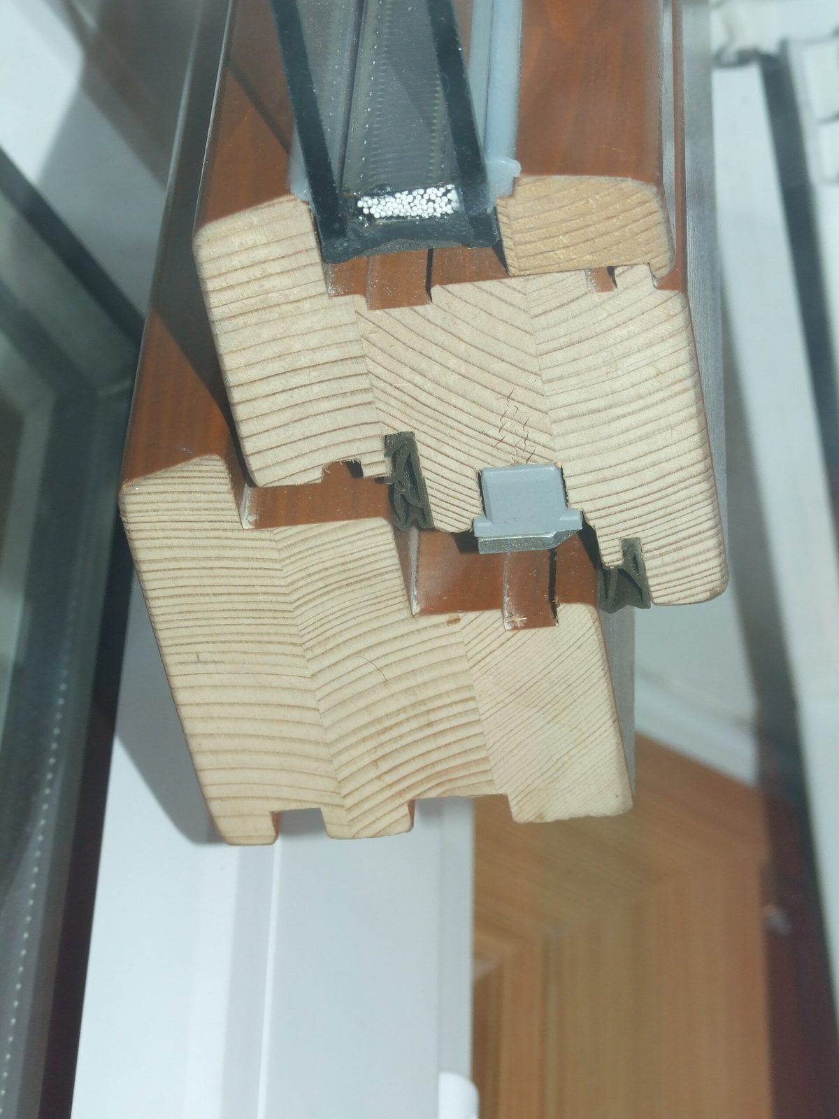 Doorsnede van een houten raamprofiel met isolerende beglazing, waarin de dichtingen en afstandhouder te zien zijn